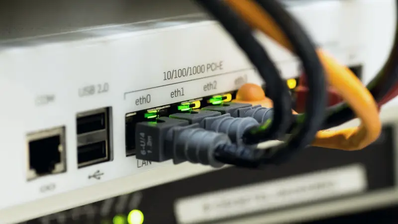 Câbles Ethernet branchés sur les ports LAN allumés d'un routeur