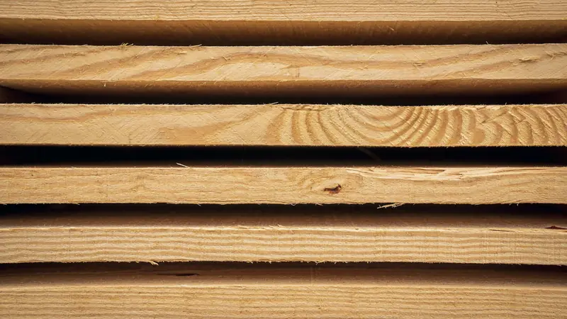 Planches de bois résineux brut empilées avec des intervalles, vues de face